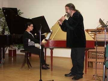 Učitelka klavíru s učitelem flétny hraje na koncertě