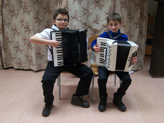 Dva žáci hry na akordeon s nástroji